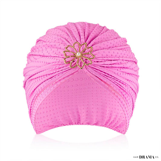 Turbante lilás com bolinhas e pregadeira de flores com pérola e metal.