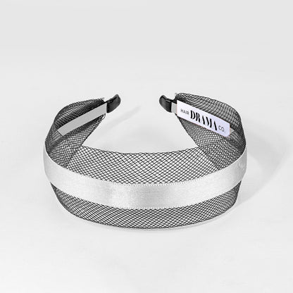 Black mesh headband with white satin band on a light gray background